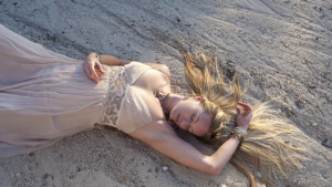 A young woman reclines on the beach