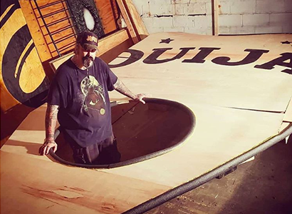 Rick Schreck poses inside the planchette of the world's largest Ouija board
