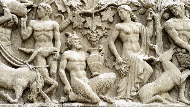 "Rome, Italy - March 3, 2012: detail of bas-relief on the facade of a stage inside CinecittA studios. This photo shows a faun (satyr in the Greek mythology) during the grape harvest. Faun is bound to Dionysus the god of the grape harvest."