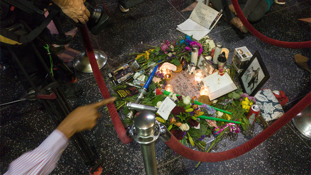 Hollywood, December 29, 2016: Tourists and camera teams around the candles and flowers on the star of Carrie Fisher on the sidewalk of Hollywood Boulevard.
