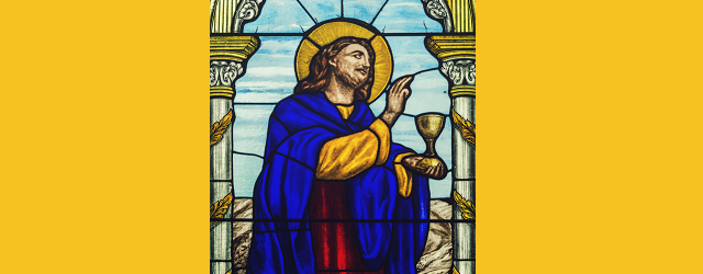 Stained glass image of Jesus holding a cup