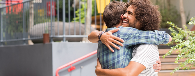 Two young men embrace