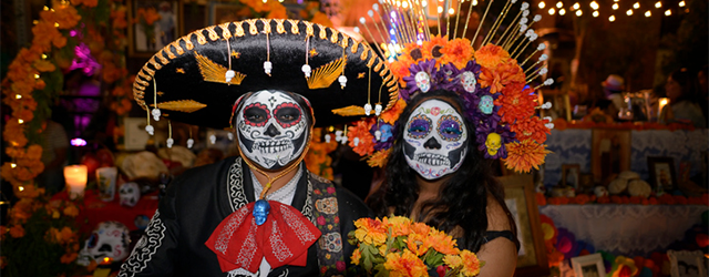Participants standing in front of an altar during Día de los Muertos.
