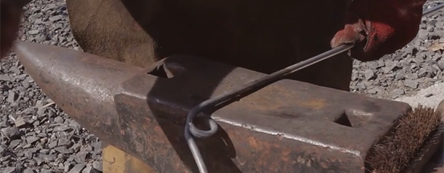 A blacksmith works at an anvil