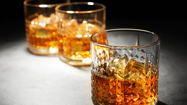 Three glasses of bourbon with ice